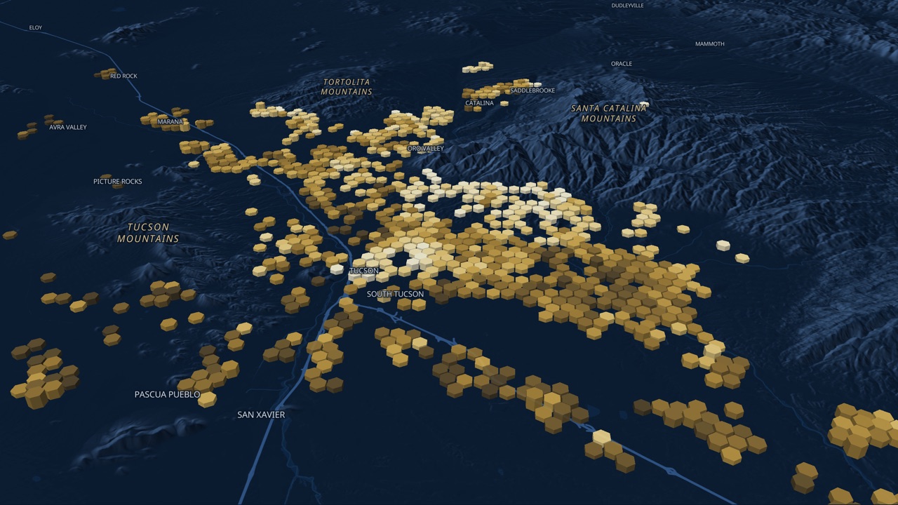 Market Pulse: a 3D map of greater Tucson at dusk, with gold columns showing where homes sold and what they cost per square foot.